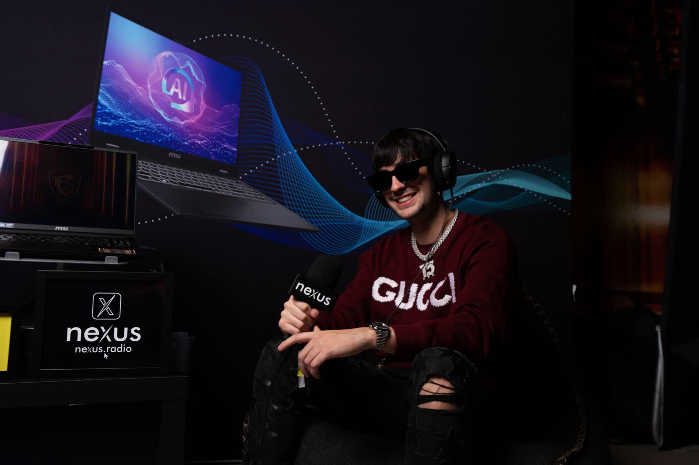 Thomas Deil on air beside the Nexus Radio sign in the lounge