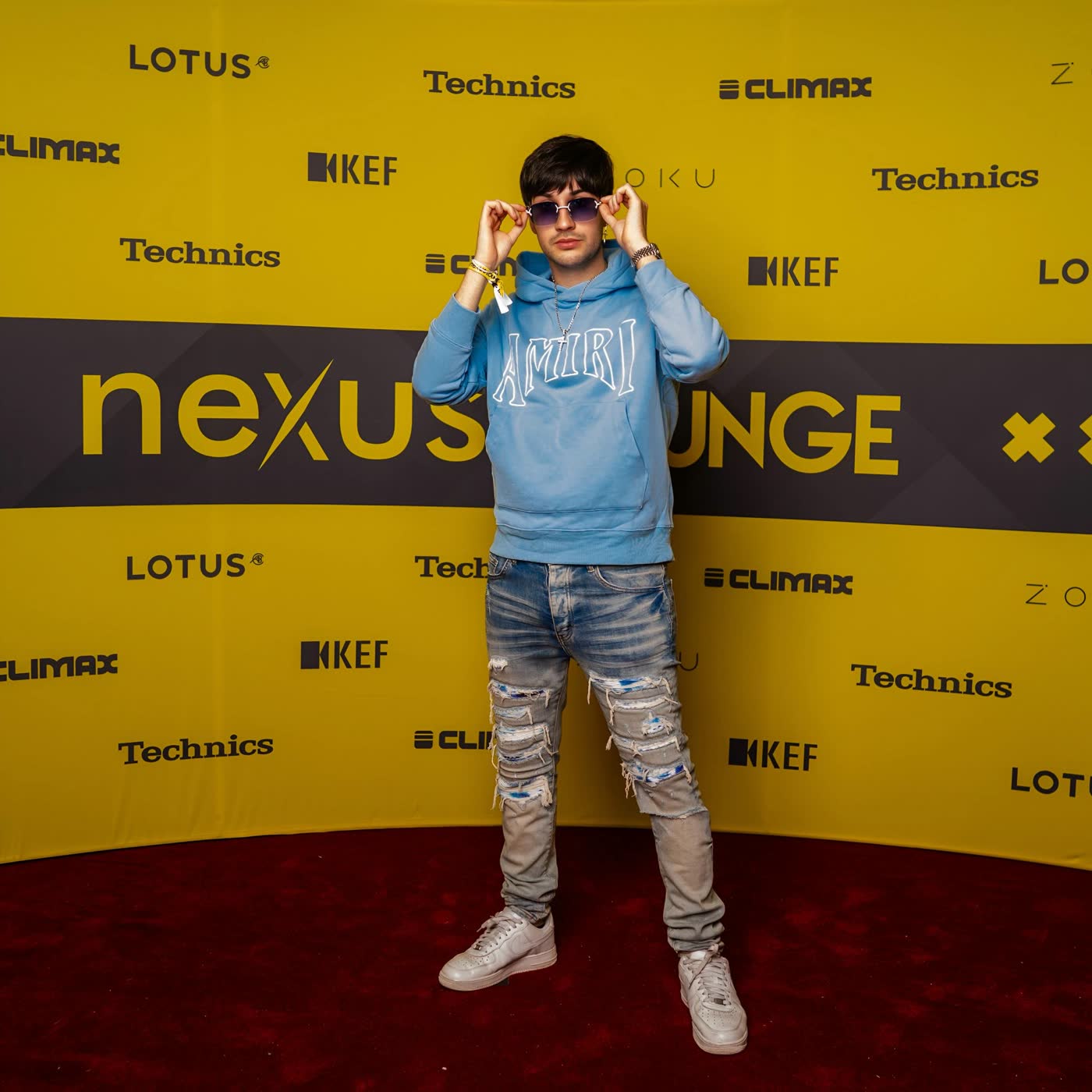 Thomas Deil on the red carpet at the Nexus Lounge sponsor wall
