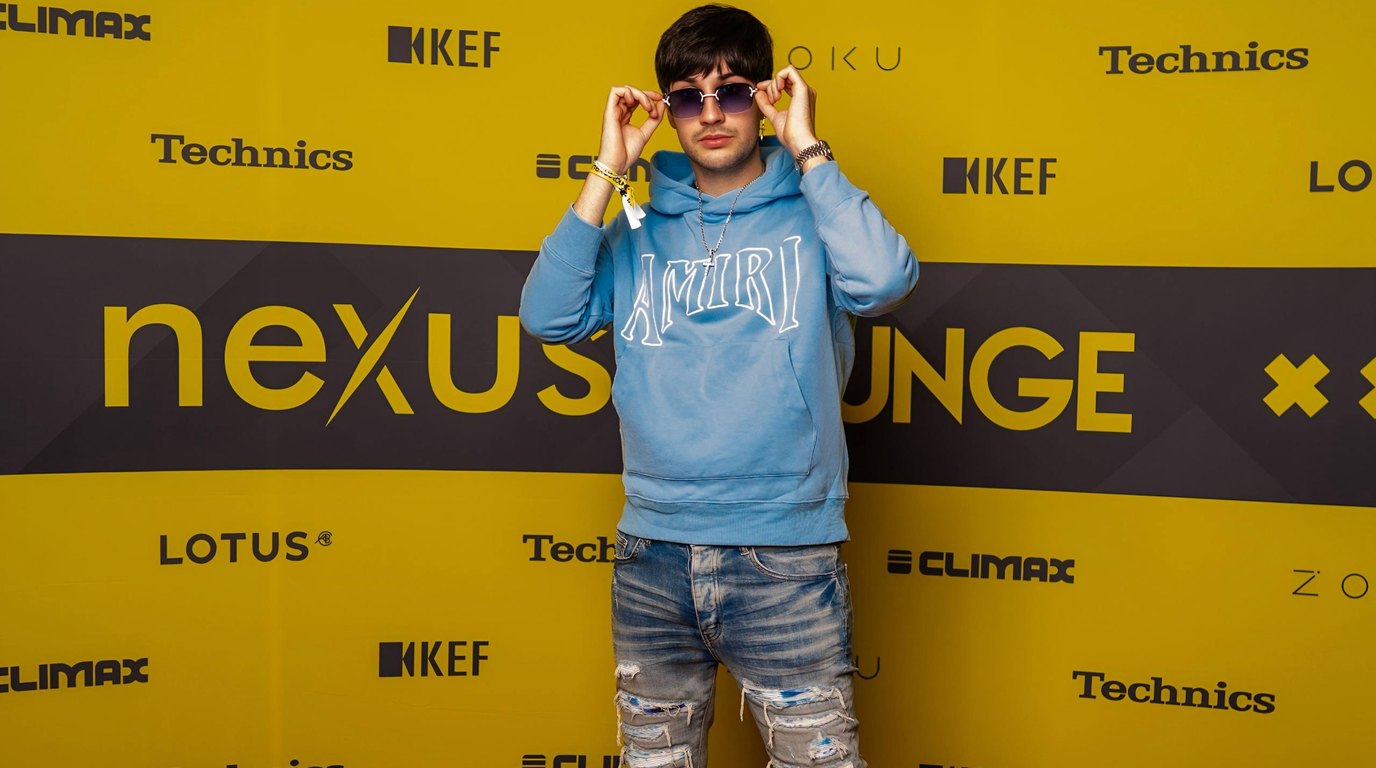 Thomas Deil on the Nexus Lounge red carpet at Amsterdam Dance Event in a previous year, standing in front of a yellow backdrop with Lotus, KEF, Technics, Climax and Zoku sponsor logos
